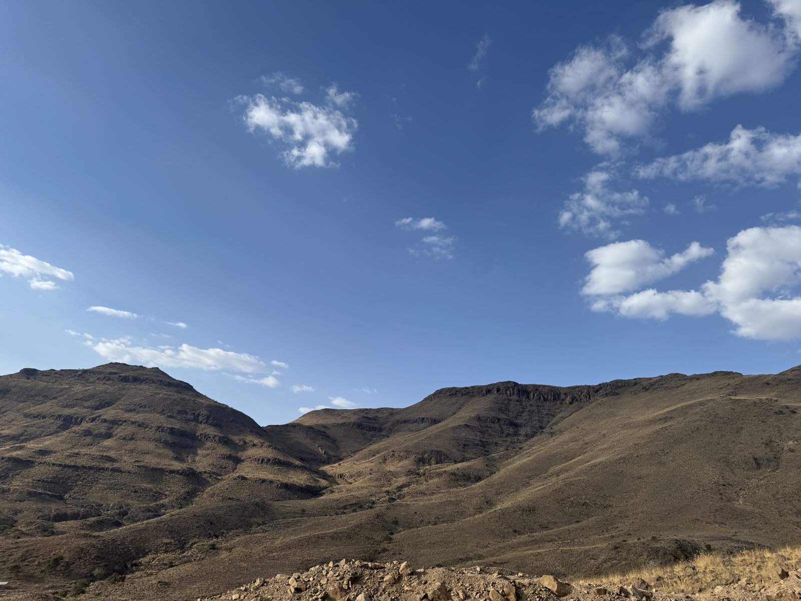 A wide view of exposed rock slopes and the surrounding mountainous terrain.